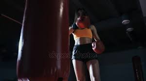 young woman boxing punching bag in a