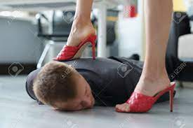 Woman In Red Shoes Stepping On Head Of Young Man In Suit In Office Stock  Photo, Picture and Royalty Free Image. Image 171371860.