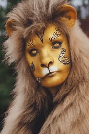womans face painted like a lion gold