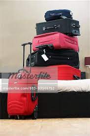 stack of suitcases on bed stock photo