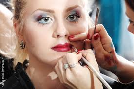 makeup artist applying lipstick on