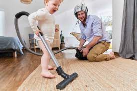 cute baby boy cleaning carpet with