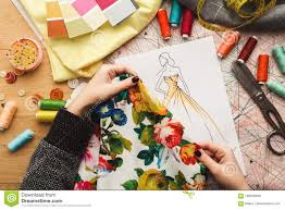 Female Fashion Designer Working With Fabric Sample And Drawn