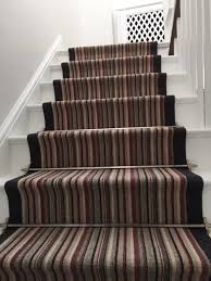 striped carpet to stairs with black