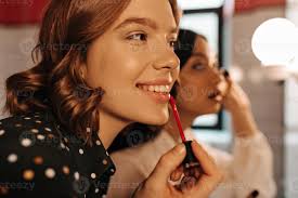 young women applying lip gloss