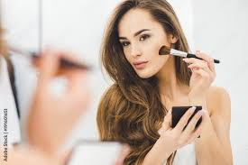 young woman applying makeup stock photo