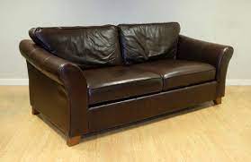brown leather two seater sofa on wooden