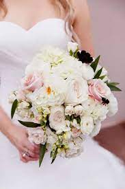 bride holds large pale pink and white