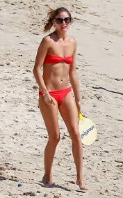 Con il suo snella corpo e Marrone chiaro tipo di capelli senza reggiseno (dimensione coppa 32A) sulla spiaggia in bikini
