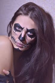 photo of woman putting skull makeup