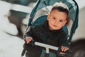sweet baby boy in a stroller bicycle