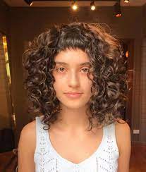 The curtains hairstyle is a famous '90s men's cut where the hair on top is left longer and styled with a strong middle part to create the appearance of curtains. Curtain Bangs On Wavy Curly Hair