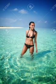 Beautiful Girl In A Bikini Standing Knee Deep In Sparkling Sunlit Water In A Tropical Lagoon In The Maldives While On Summer Vacation Stock Photo, Picture And Royalty Free Image. Image 95079377.