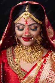 young indian bride in red sari and gold