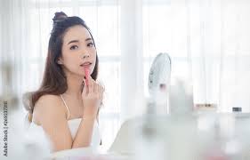 young beautiful asian put lipstick