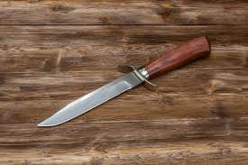 Los cuchillos de caza son cuchillos que, en general, tienen la función de ser utilizados en la naturaleza para cazar piezas de animales en situaciones de supervivencia. Caza Cuchillo De Acero De Damasco Hecho A Mano Sobre Una Superficie De Madera Primer Plano Foto Premium