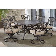 Hanover Traditions 7 Piece Outdoor Dining Set With Round Cast Top Table And 6 Swivel Rockers Beige