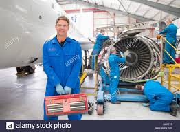 Team Of Aero Engineers Working On Aircraft In Hangar Stock Photo