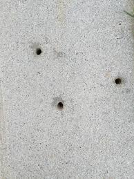 2 holes in concrete floor in front of