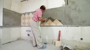worker installing tiles kitchen wall