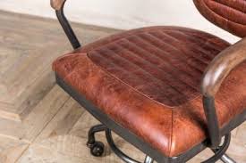 The chair displays a mid brown oak colour. Vintage Style Office Chair Peppermill Interiors