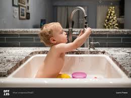The american academy of pediatrics says to give your baby a sponge bath until the. Baby Bathing In Kitchen Sink Stock Photo Offset