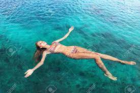 若いスリム女性横バックと青い海の水でリラックスの写真素材・画像素材 Image 53479582