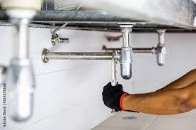 technician plumber using a wrench to