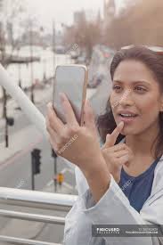 woman checking makeup with camera phone