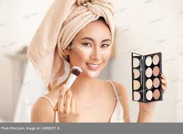 asian woman applying contouring makeup