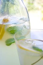 a gl jug of sugar free homemade ginger ale with mint leaves ice cubes and