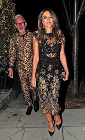 About the actual dress itself, the black evening gown was made from silk and lycra strategically held together with oversized novelty gold safety pins to reveal daring cutouts, and held up at a plunging neckline with slimline straps and more pins. Elizabeth Hurley Wows In Black Lace Dress For Night Out In London
