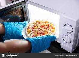 happy woman baking pizza microwave oven