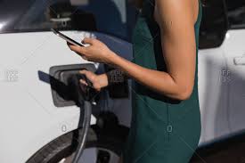 Yes, you can use it while charging. Mid Section Of Woman Using Mobile Phone While Charging Electric Car At Charging Station Stock Images Page Everypixel