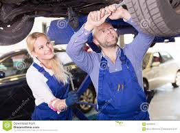 Mechanic And Assistant Working At Auto Repair Shop Stock