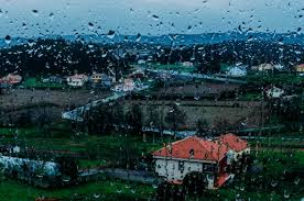 village seen from a window with rain drops
