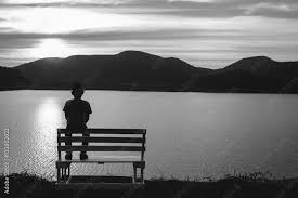 the silhouette of boy sitting alone