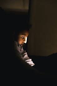 boy sitting alone in a dark room