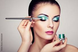 makeup artist applies eye shadow