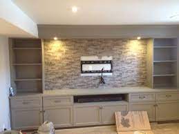 Especially in rooms that don't see natural light, it can be beneficial to lighten up the color tones—this can make the basement appear bigger and less crowded. Basement Wall Unit Wall Unit Custom Wall Unit Cabinetry Design