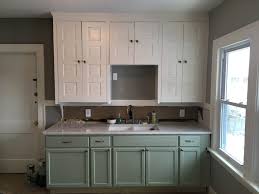 Fabulous kitchen features white apron sink accented with gooseneck faucet as well as hidden dishwasher disguised behind cabinet door. What Color Should I Paint My Kitchen Cabinets Textbook Painting