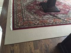 holding area rug in place over a carpet