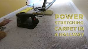power stretching carpet in a hallway