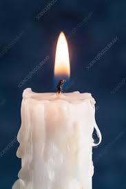 lit candle with melted wax stock