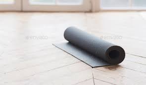 rolled up yoga mat on wooden floor