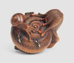 Japanese netsuke can be made from a wide variety of materials including ivory, hardwood, clay or porcelain, metal, and in rare cases, even walnuts or coral. A Wood And Inlaid Metal Netsuke Of Two Snails And Ants