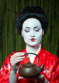 woman in geisha makeup with clay teapot