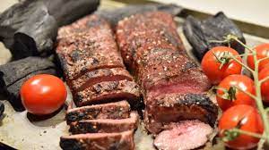 caveman grilling lamb backstrap by