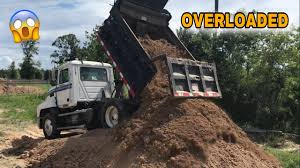 overloaded dump truck hauling dirt