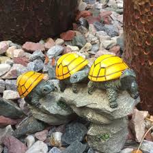 Solar Powered Turtles On Log Outdoor